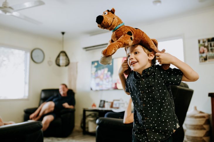 Young boy in lounge room with Scooby doo dog on his head as a hat