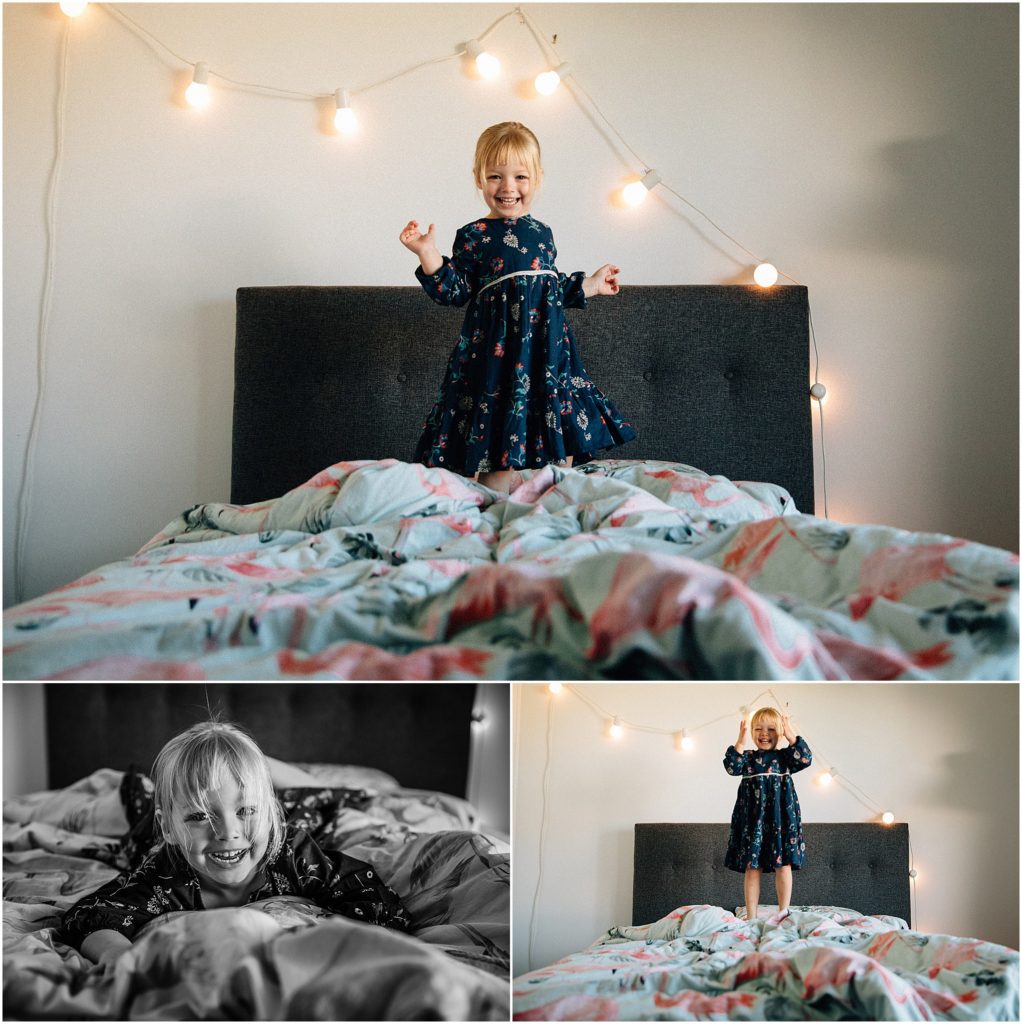 Young girl playing on bed with fairy lights