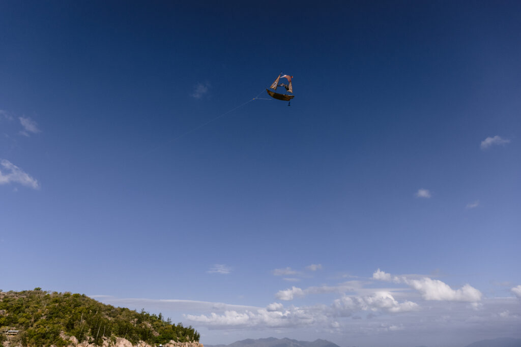 The pirate ship kite flies high in the blue sky on Geoffrey Bay at Magnetic island.