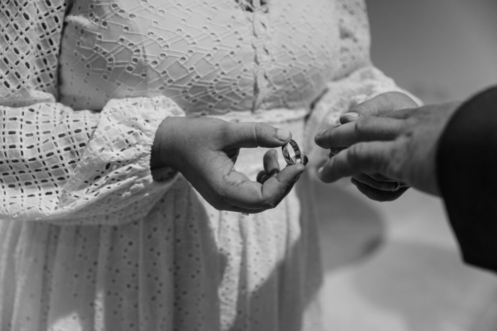 Hannah places the wedding ring on Terry's finger during their elopement ceremony.