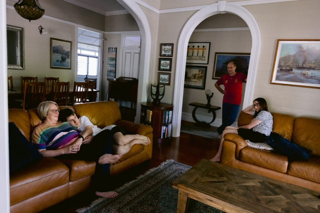 A very natural photo of the family are relaxed in their lounge room. 
