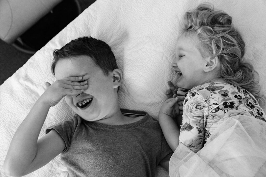 Brother and sister joyfully play together laughing