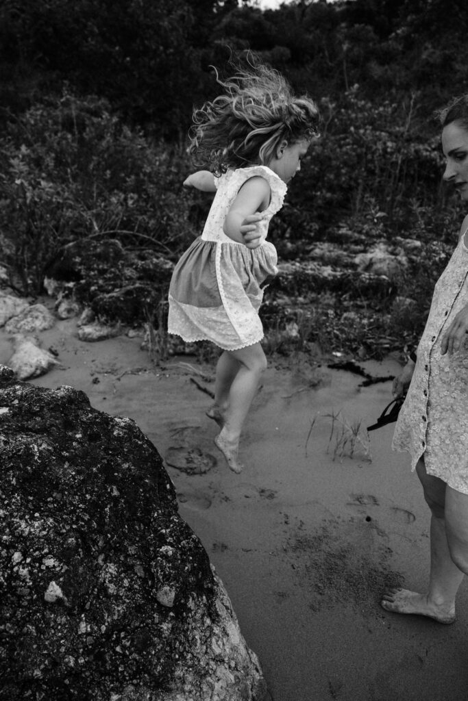 Its getting dark and the daughter jumps off the rock as we prepare to leave the beach after family photos. 