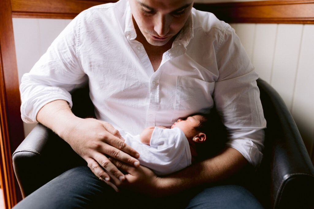 Newborn baby boy in his fathers arms