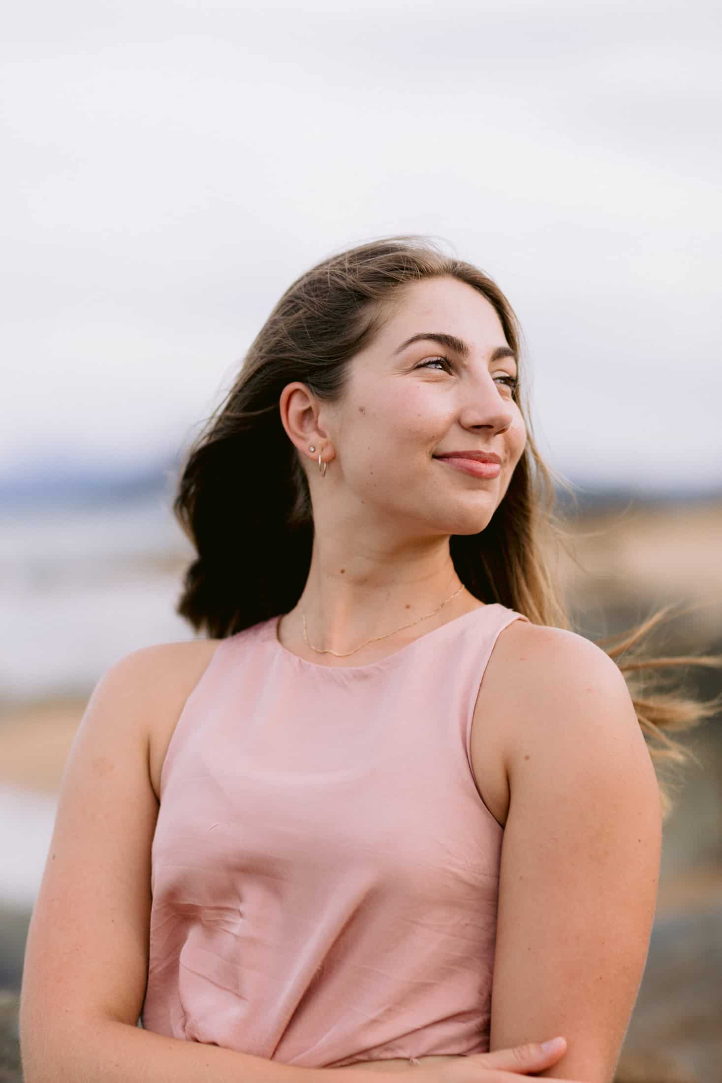 A young women smiles gently looking off to the side