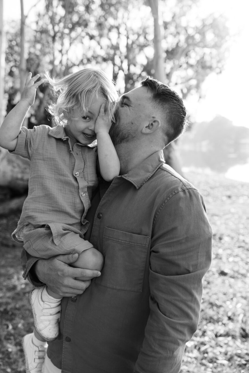 a father is holding his son and they are playful