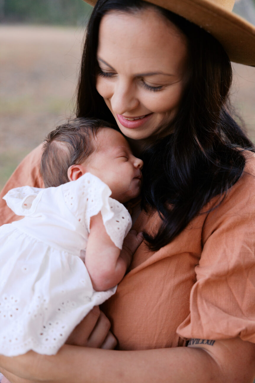 a mother gently smiles at her newborn