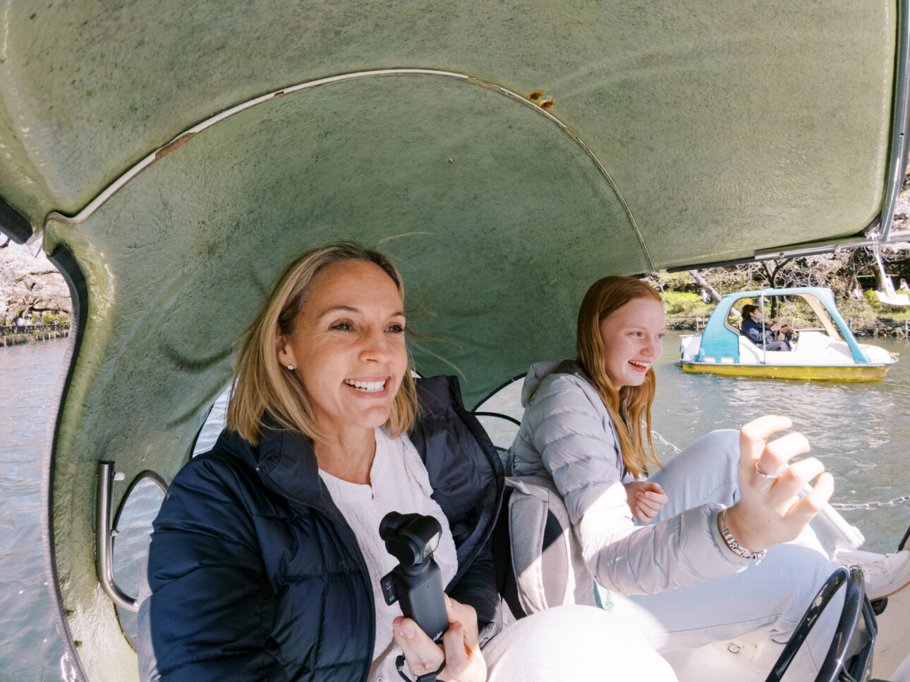 A mother and daughter are in a swan paddle boat very happy in Inokashira Park