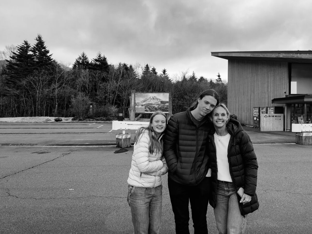 Photo of a mother with her son and daughter. In a carpark near mt Fuji, but Mount Fuji is covered by clouds