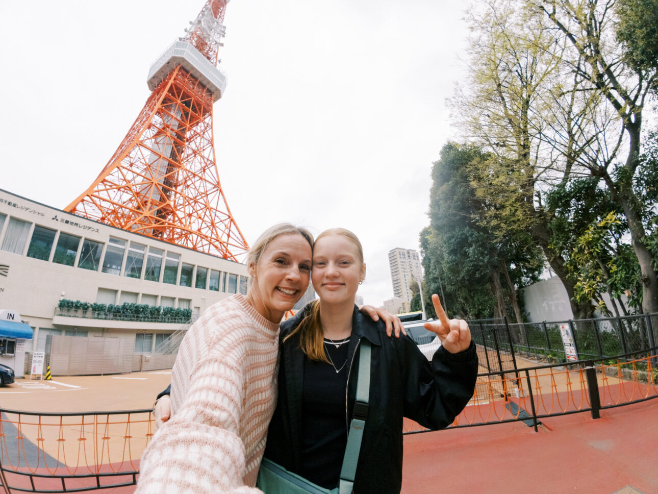 a mother and daughter are staying in front of Tokyo tower on their girls trip to Japan