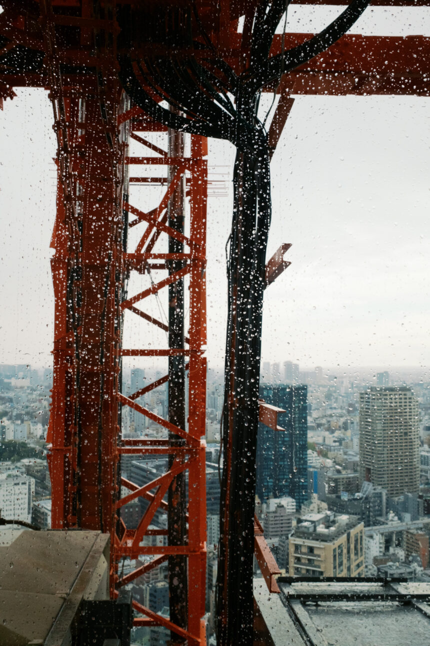 A photo taken of a window at Tokyo tower with raindrops on it