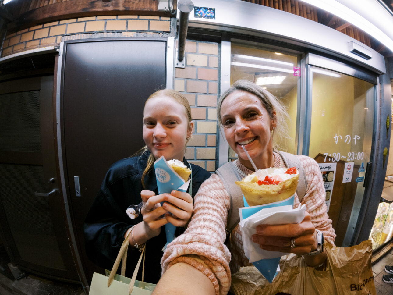 A mother and daughter eating crepes late at night in Shinjuku on a girls trip to Tokyo